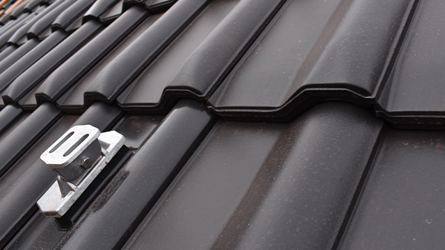 Detailaufnahme von Dach mit Flachdachpfanne W6v und integriertem Solarträger